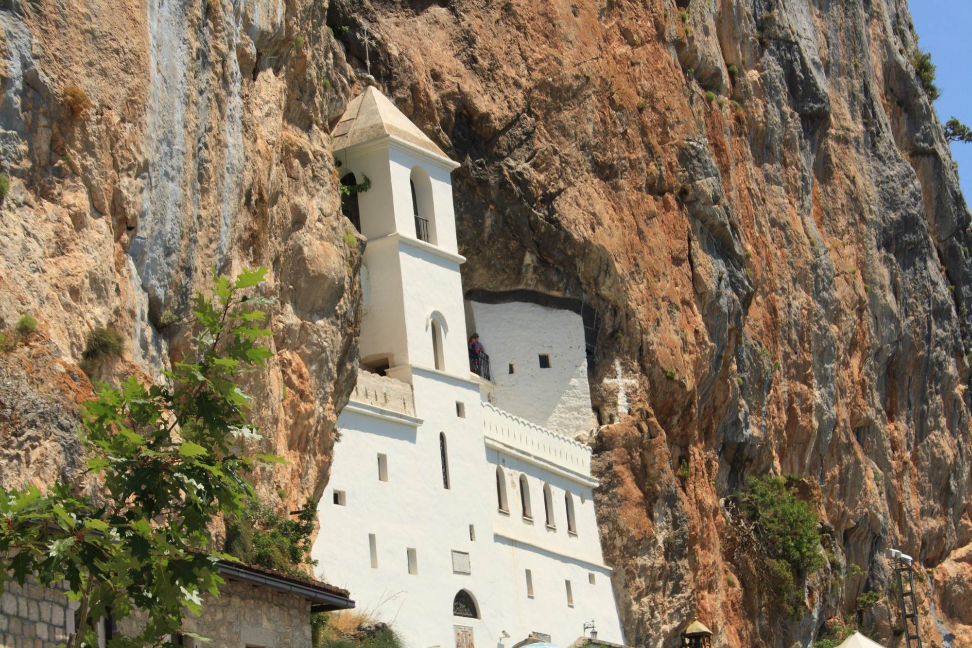 The bell tower and white walls of the Upper Monastery against the cliff